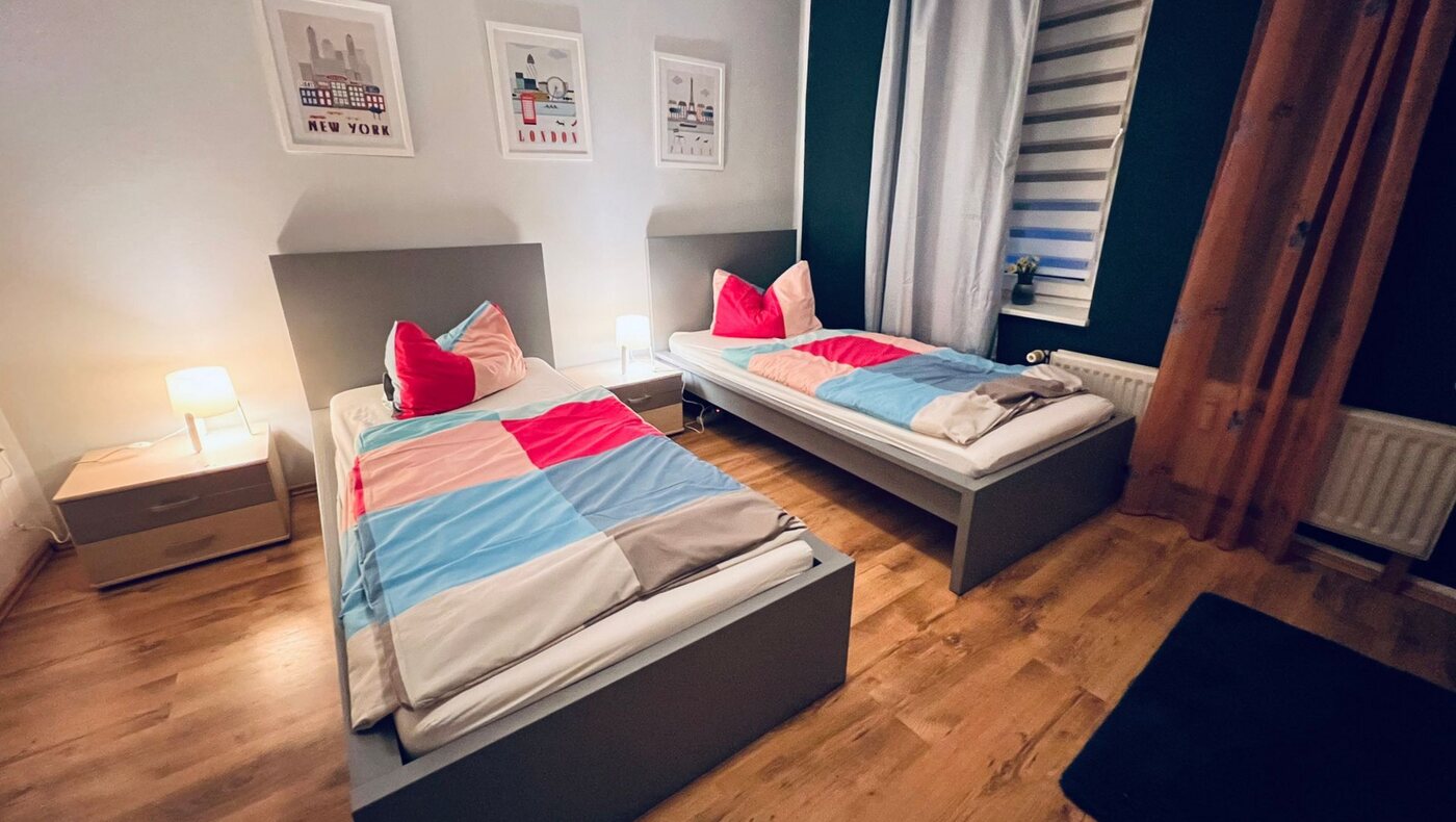 Schlafzimmer einer Monteurwohnung mit frisch bezogenen Einzelbetten