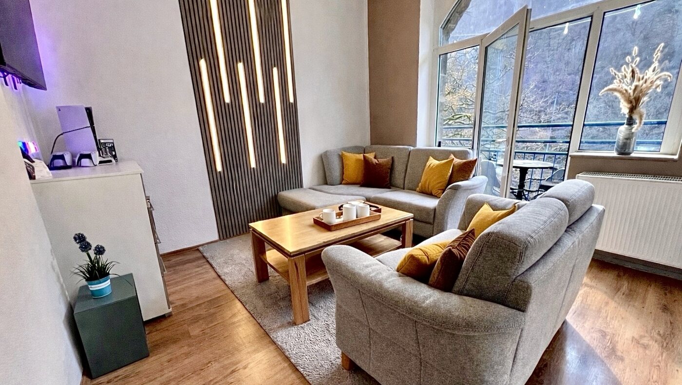 Wohnzimmer mit LED-Wand und Balkonblick